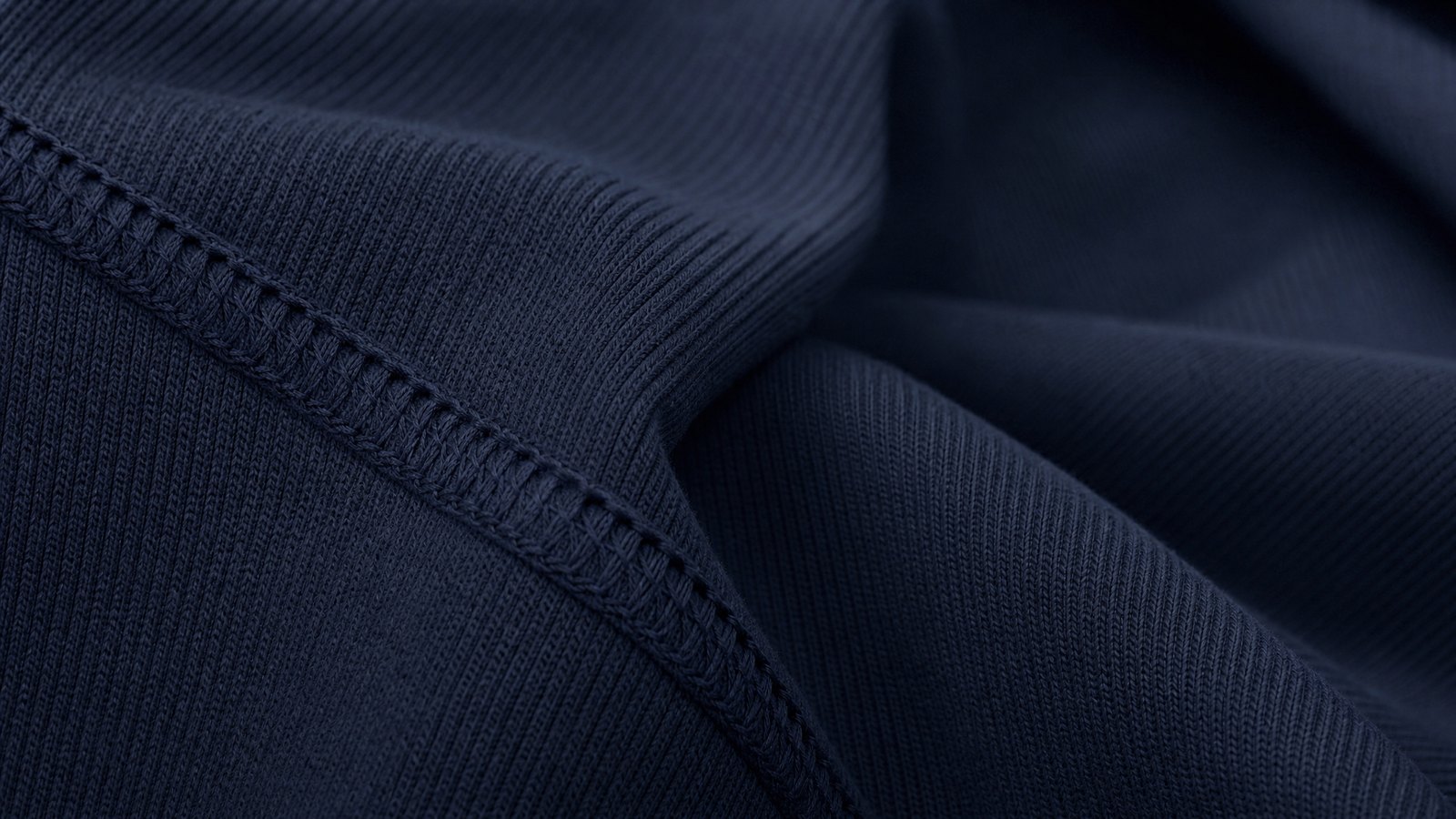 Close detail of overlapping charcoal ribbed and oatmeal cable knitted fabric